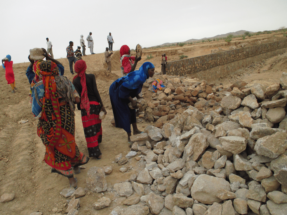 Women participating in the collection and transportation of rock to the dam site in return for food for work